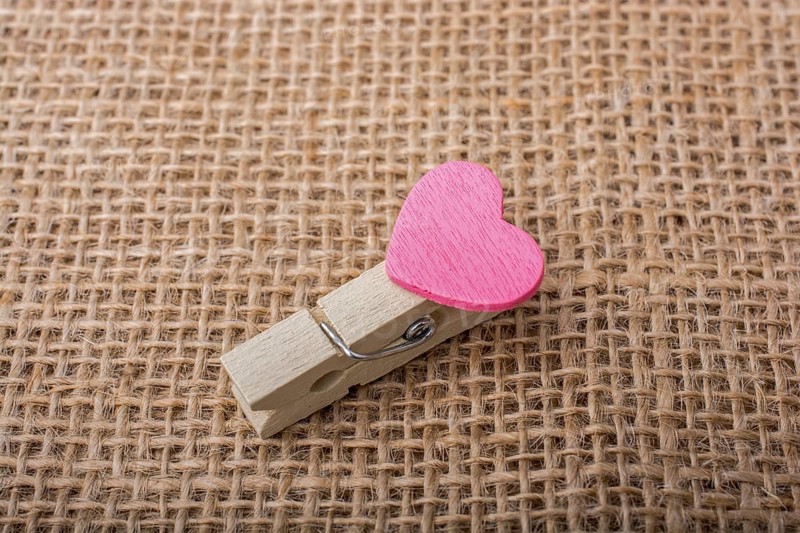 Colorful heart attached to a clothespin in hand