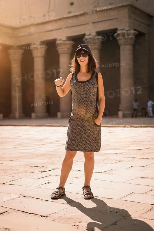 A young tourist wearing a cap visiting the Edfu Temple at sunrise in Aswan. Egypt