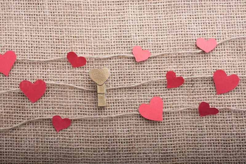 Love concept with heart shaped papers on linen threads