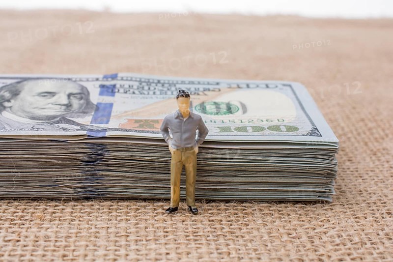 Man figurine found beside the bundle of US dollar banknote