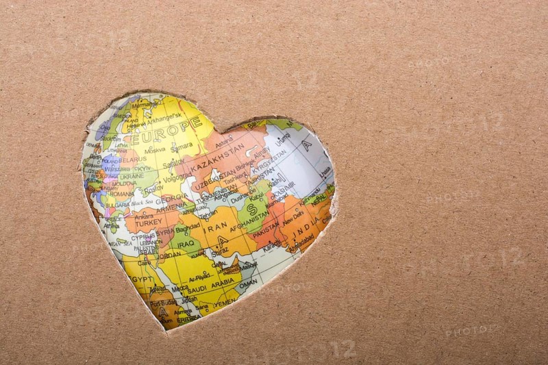 Globe seen through the heart shape hole on paper