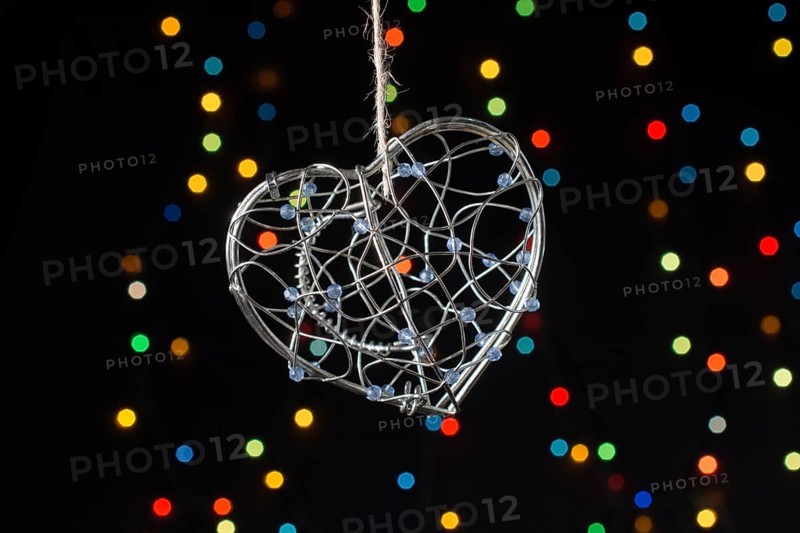 Heart shaped metal cage on a bokeh light background