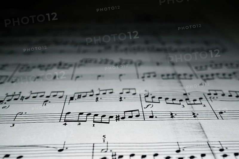 Close-up of sheet music with blurred black background