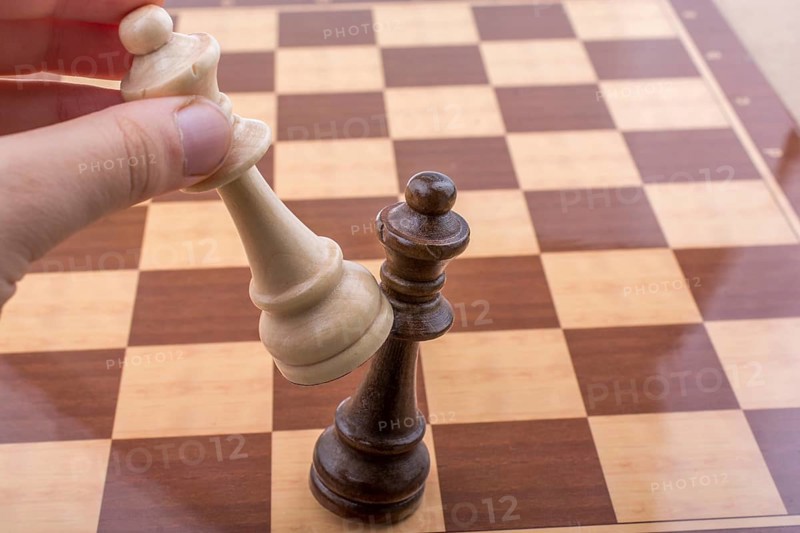 Person playing chess game making a move on board