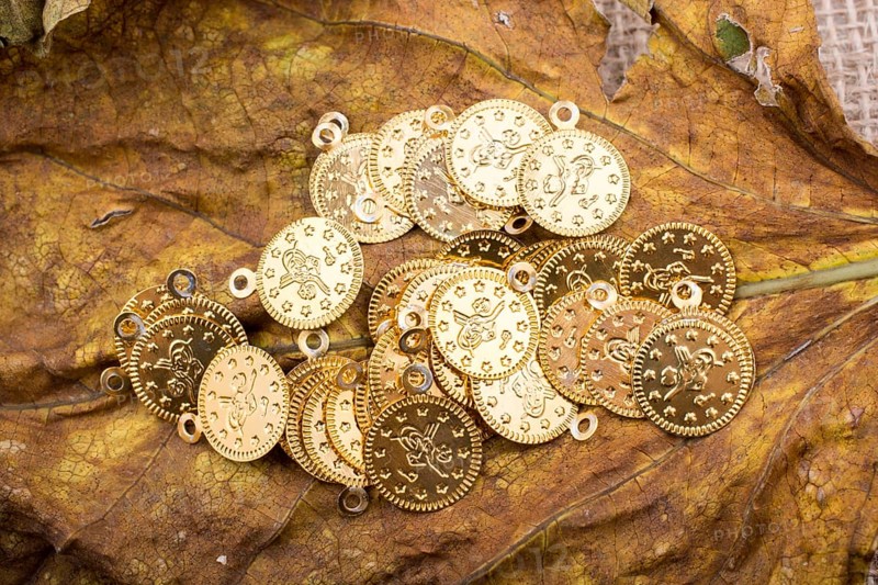 Plenty of fake gold coins are on a dry leaf