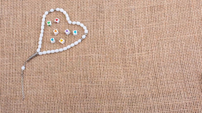 Heart shaped cubes in hand by inside a praying beads