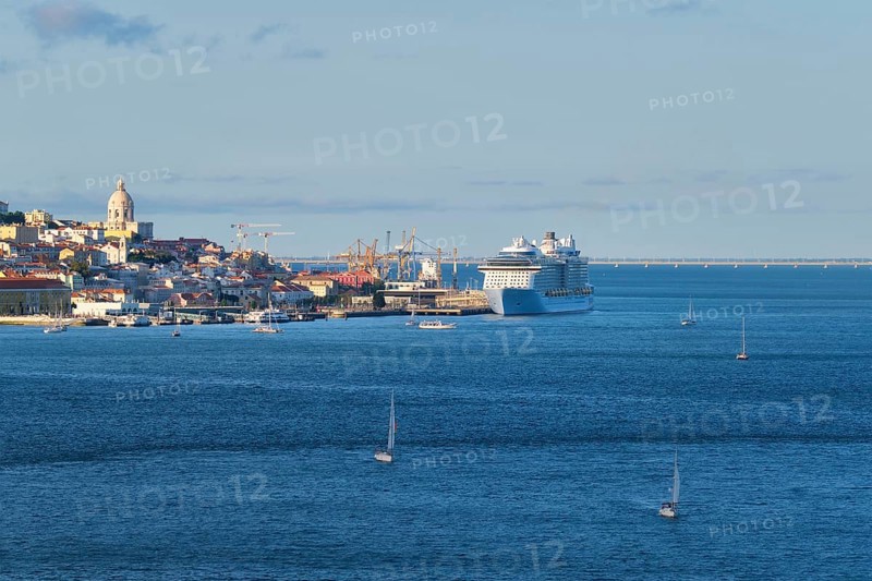 View of Lisbon over Tagus river from Almada with yachts tourist boats and moored cruise liner on sunset. Lisbon