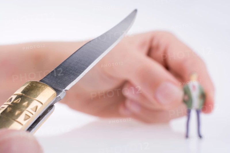 Hand holding a pocket knife near a human figure on a white background