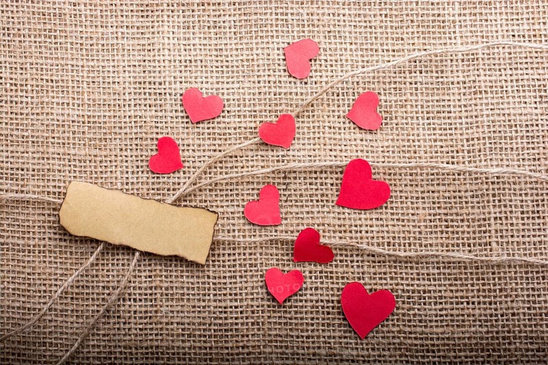 Love concept with heart shaped papers on linen threads