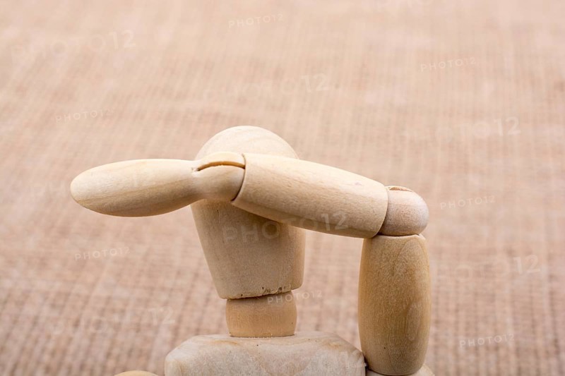 Wooden dolls of a man posing on canvas