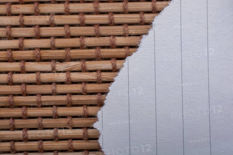 Piece of torn paper on a straw background