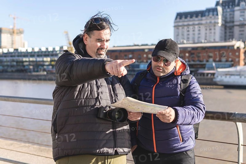 Couple of friends consulting the map while exploring Puerto Madero
