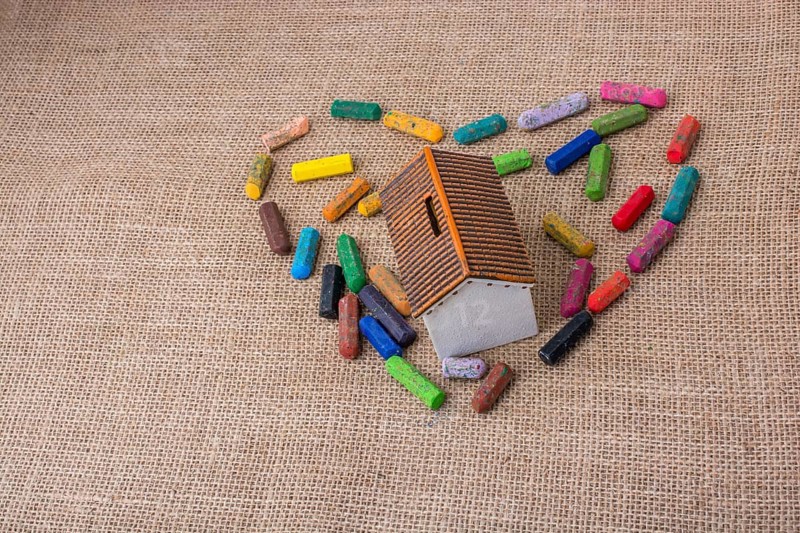 Globe in the middle of crayons form a heart shape