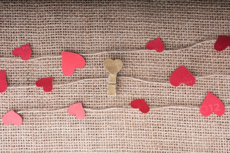 Love concept with heart shaped papers on linen threads