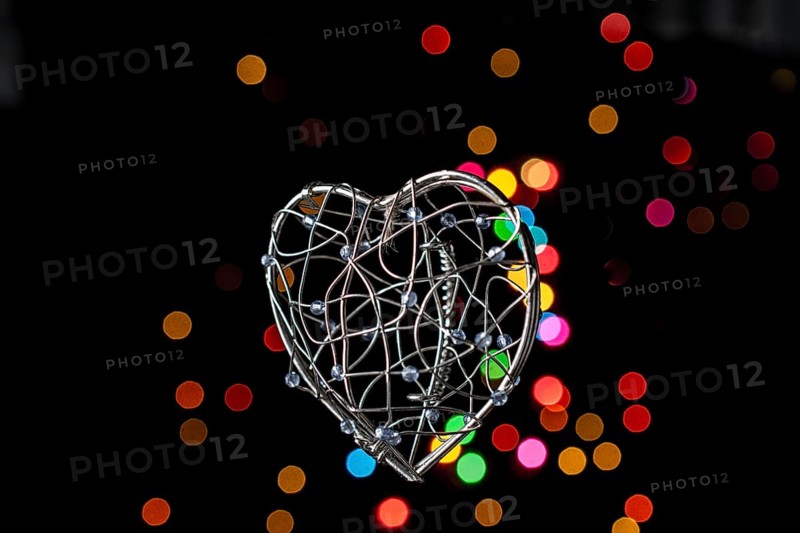 Heart shaped metal cage on a bokeh light background