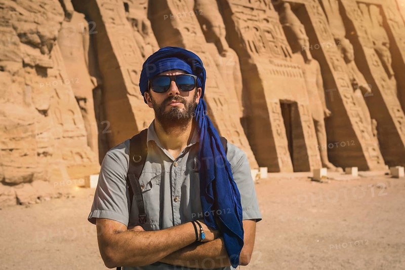 A young man wearing a blue turban visiting the Egyptian Temple of Nefertari near Abu Simbel in southern Egypt in Nubia next to Lake Nasser. Temple of Pharaoh Ramses II