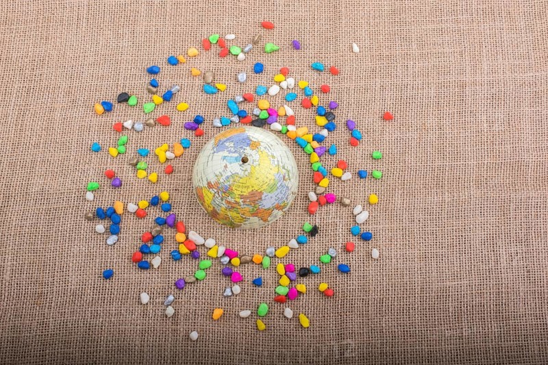 Model globe placed amid colorful pebbles