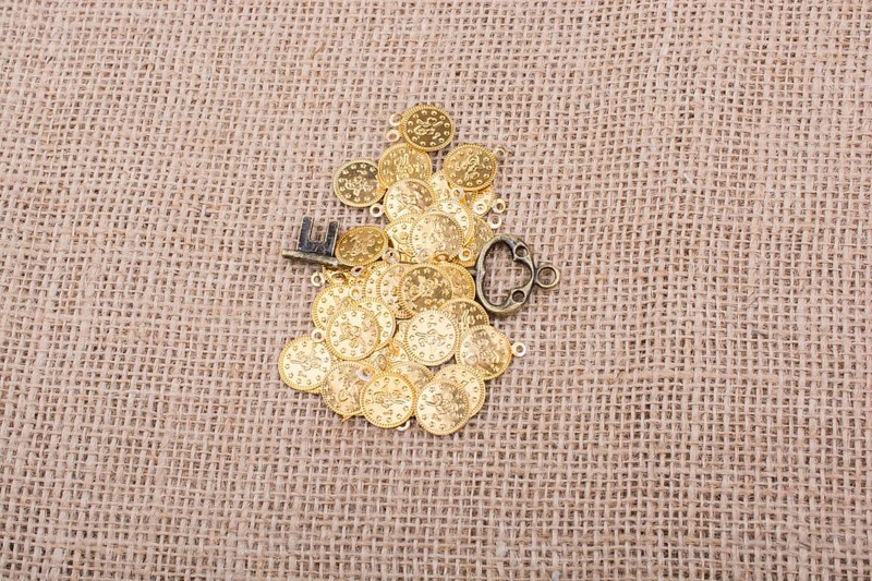 Retro styled key placed over fake gold coins