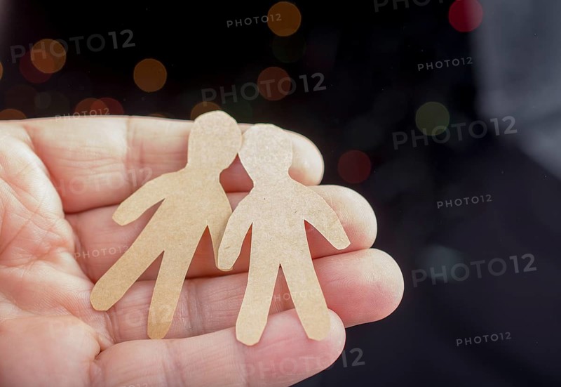 Paper man shape in hand on bokeh light background