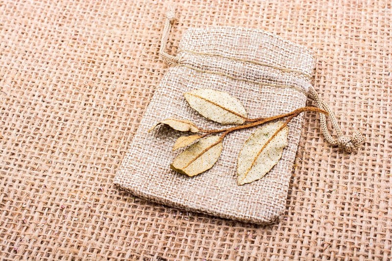 Dry green leaves on a sack on linen canvas