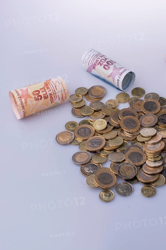 Turkish Lira coins and banknotes side by side on white background