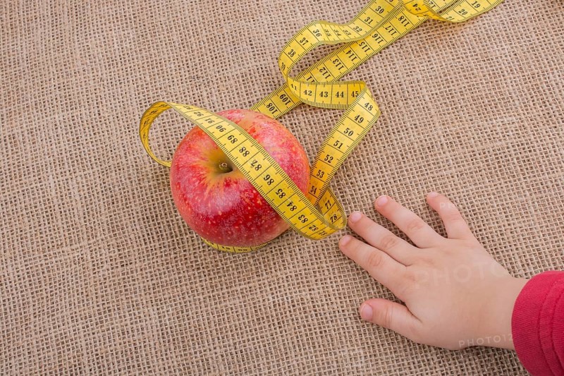 Health and diet concept with apple with a measurement tape