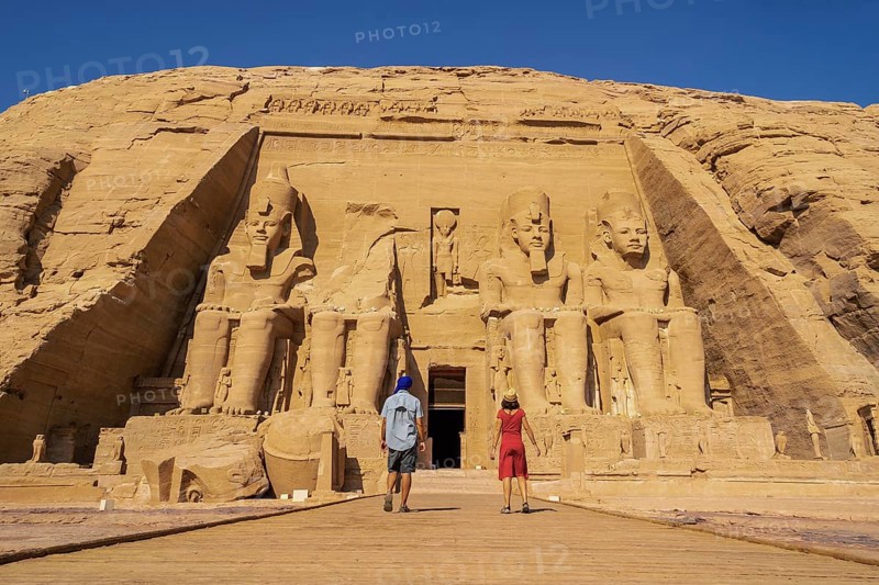 A tourist couple visiting the Abu Simbel Temple in southern Egypt in Nubia next to Lake Nasser. Temple of Pharaoh Ramses II