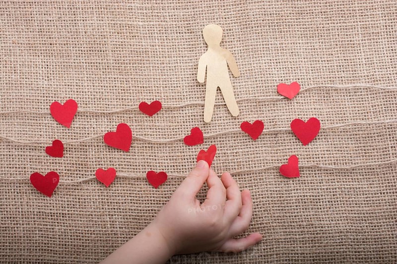 Man shape cut out of paper in hand in the view