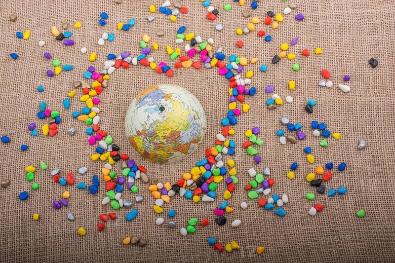 Globe in the heart form shaped by colorful pebbles