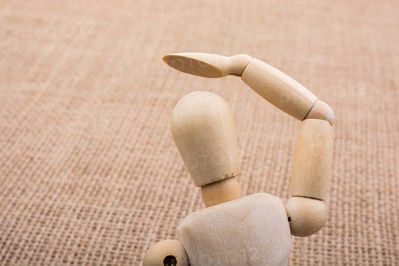 Wooden dolls of a man posing on canvas