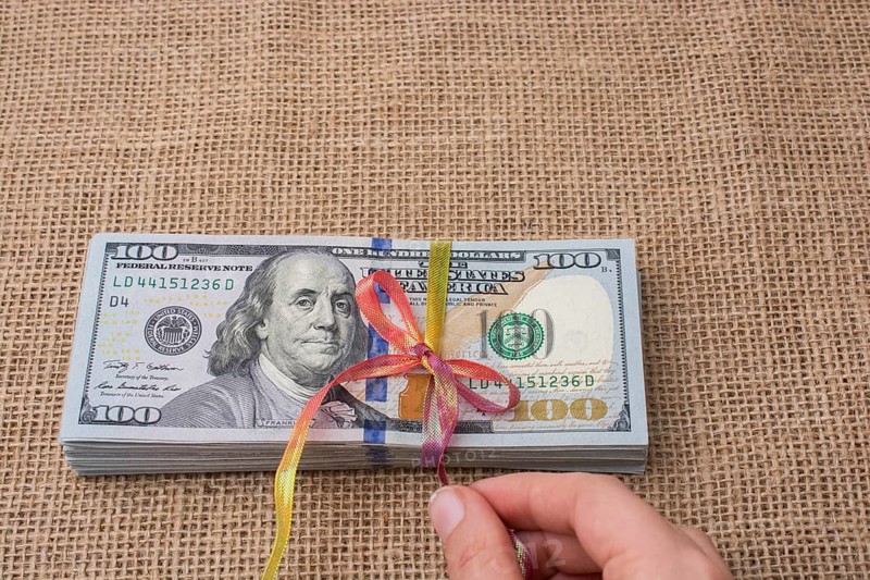 Banknote bundle of US dollar tied with colorful a ribbon
