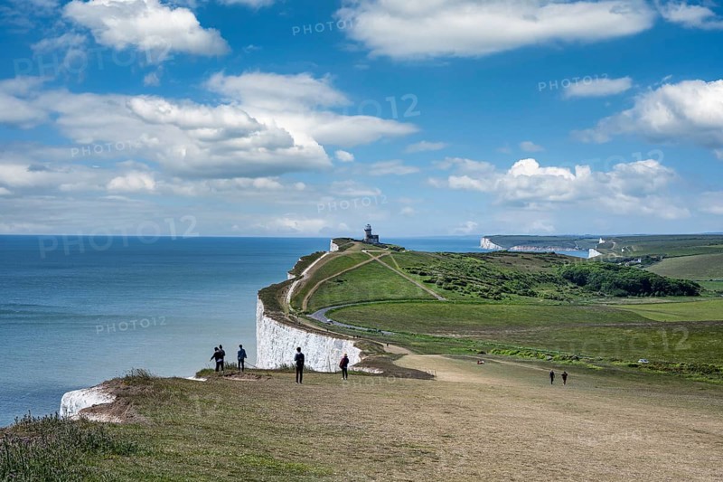 Tourists on the edge of the chalk cliffs at Beachy Head