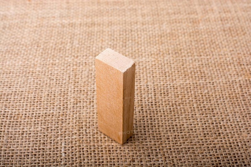 Wooden domino on a linen canvas background
