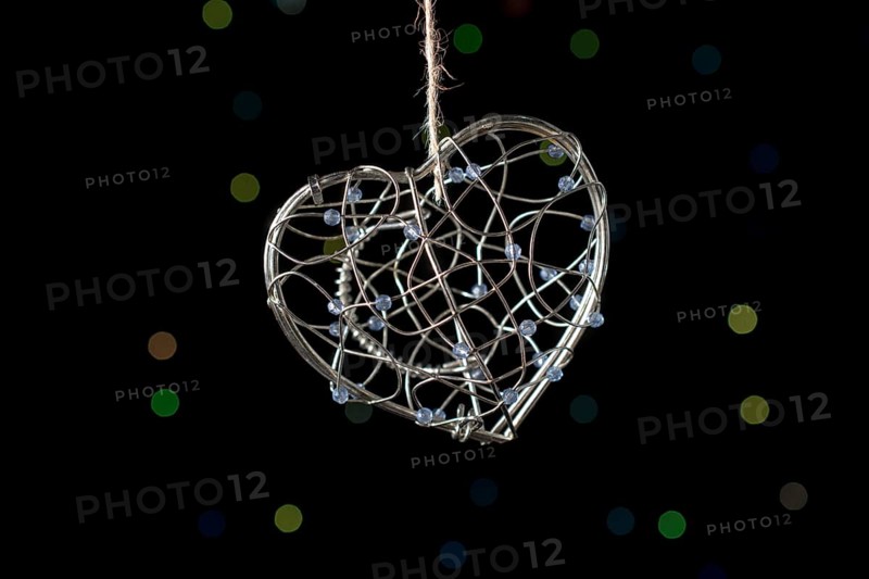 Heart shaped metal cage on a bokeh light background