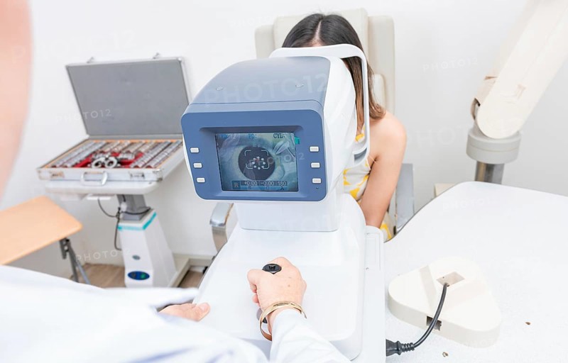 Optometrist using refractometer with patient. Eyesight of a patient on the screen of the refractometer