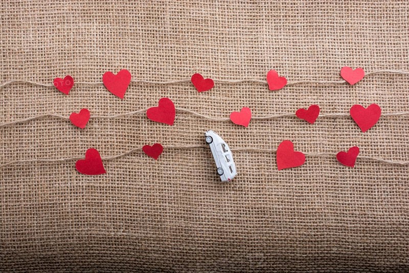 Love concept with car and paper heart on linen threads
