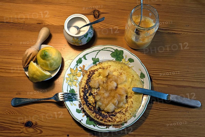 Pancakes with apple sauce and lemon on a plate