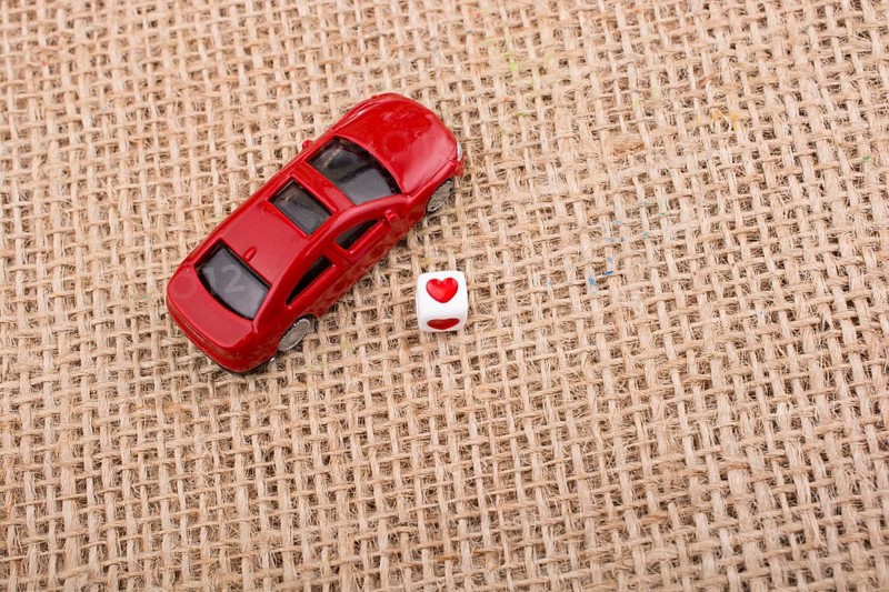 Love cube on a red toy car on a linen canvas