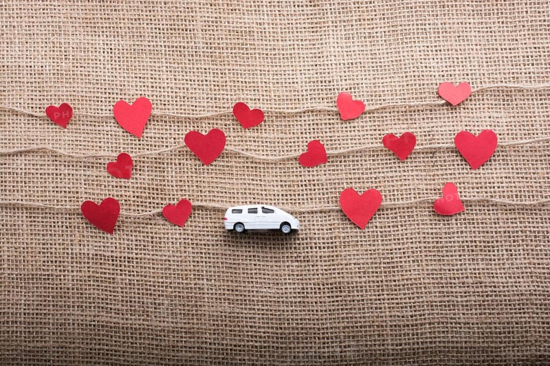 Love concept with car and paper heart on linen threads