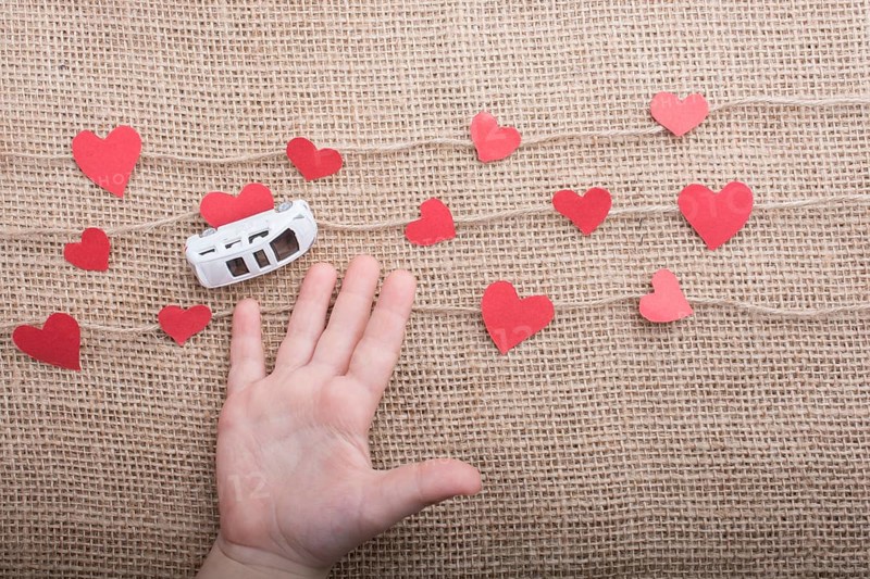 Love concept with car and paper heart on linen threads