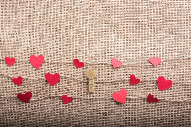 Love concept with heart shaped papers on linen threads