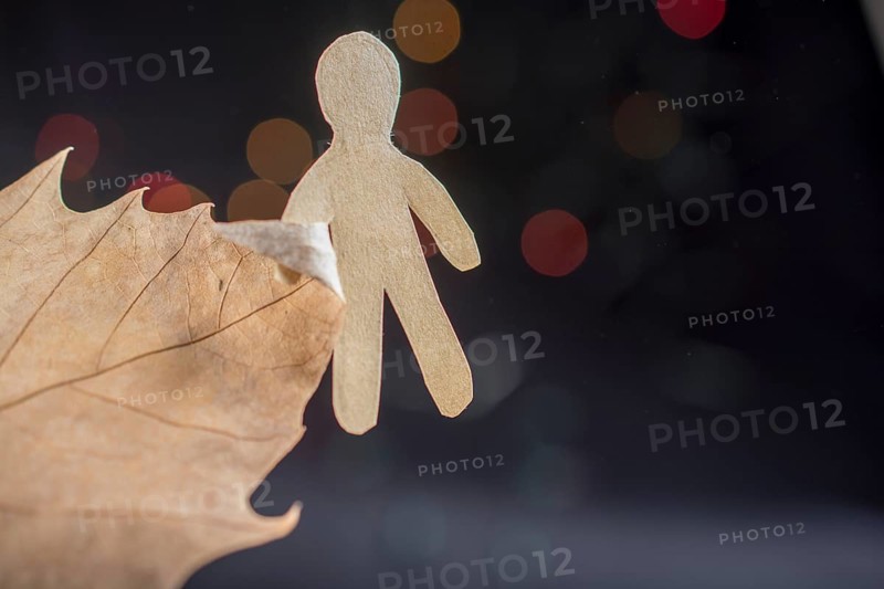 Paper man shape in hand on bokeh light background