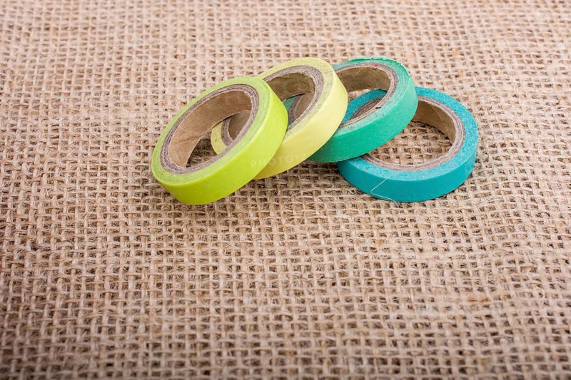 Colorful insulating adhesive tape on linen canvas background