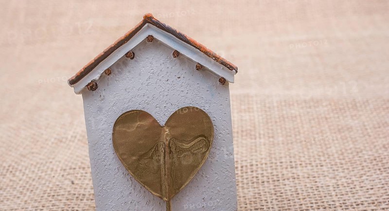 Heart shape icon placed on a little model house