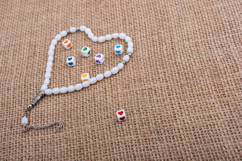 Heart shaped cubes in hand by inside a praying beads