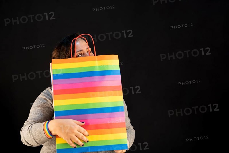 Woman holding lgbt bag. Joy of consumption. Purchases