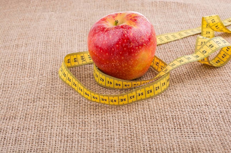Health and diet concept with apple with a measurement tape