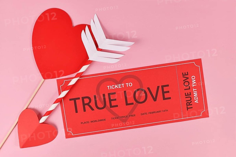 Cute Valentine's day concept with 'True Love' ticket and cupid arrow on pink background