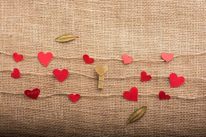 Love concept with heart shaped papers on linen threads