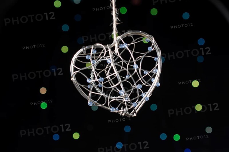 Heart shaped metal cage on a bokeh light background
